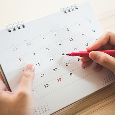 Image of hands holding a calendar and red marker